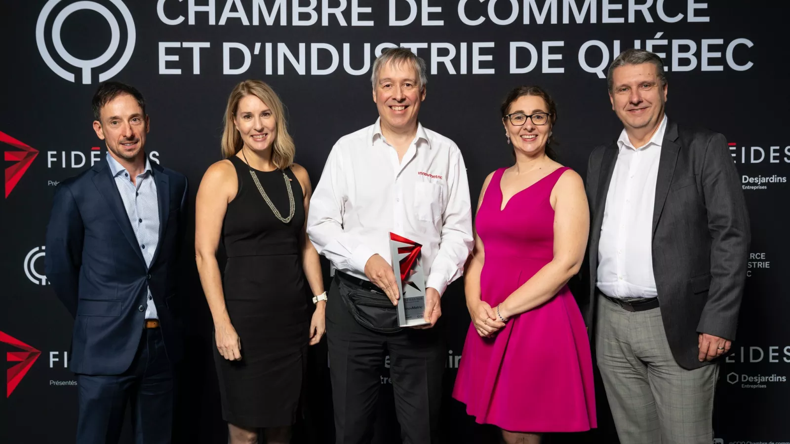 La delegación de InnovMetric en el escenario, recibiendo con orgullo el premio Rayonnement Hors Québec.